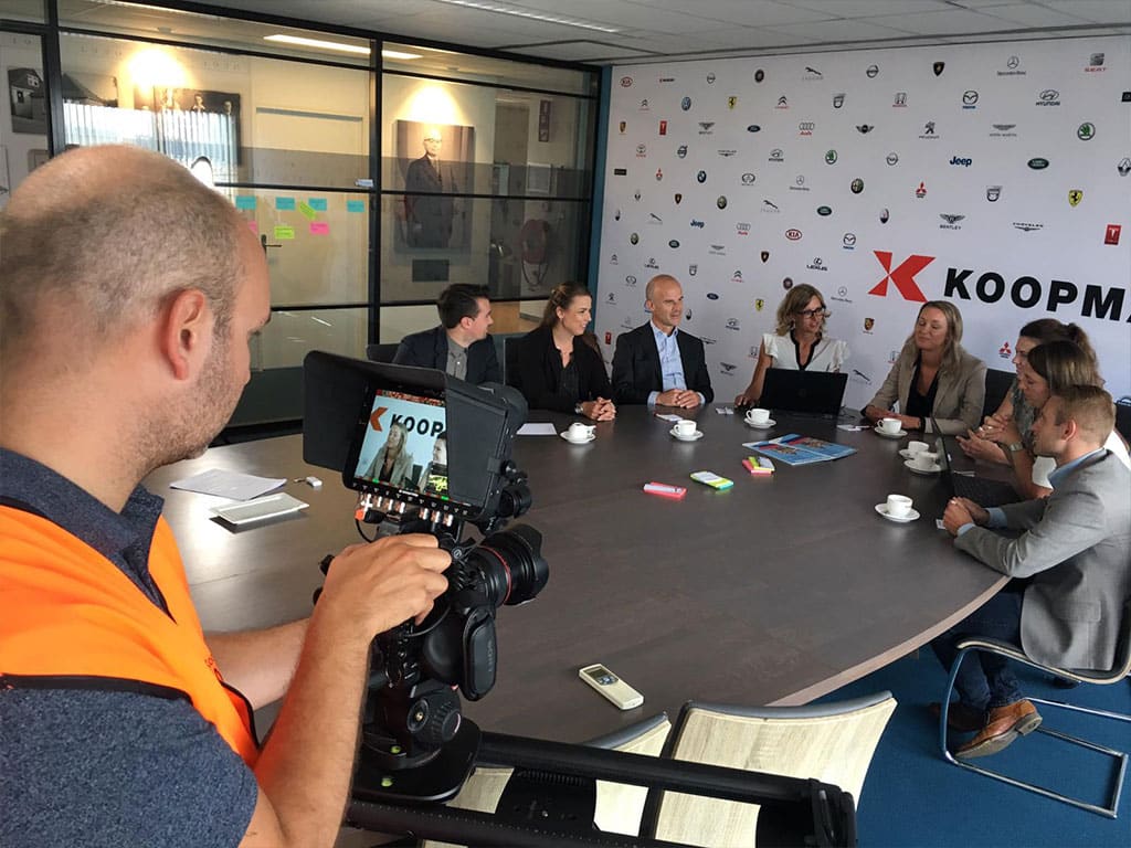 Cameraman filmt medewerkers van Koopman Logistics aan een ronde vergadertafel tijdens de productie van het merkverhaal door Mondha Media