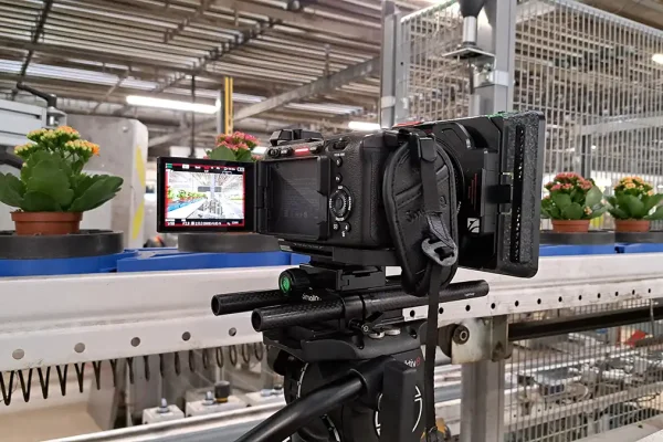 Cameraman en geluidsman van Mondha Media filmen een medewerker van gemeente Zaanstad voor een industrieel bakstenen gebouw