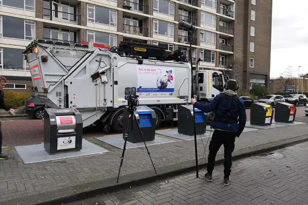 Cameraman met hengel filmt de ondergrondse containers en vuilniswagen van gemeente Utrecht voor de voorlichtingsfilm over karton recyclen