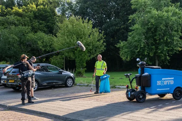 Filmcrew neemt een buitendienstmedewerker van gemeente Zaanstad op terwijl hij met een afvalprikker zwerfafval opruimt