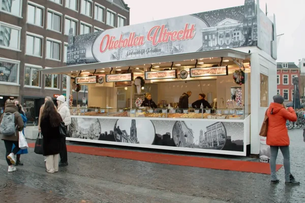 Oliebollen in Utrecht – frituurvet-voorlichtingsfilm Oliebollenkraam op een plein in Utrecht met wachtende klanten in de winter