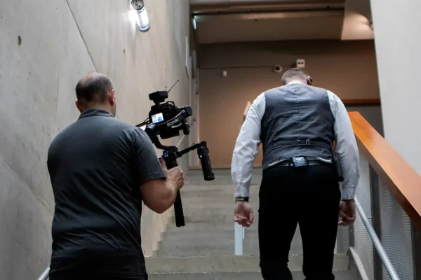 Testimonial VVNL — opname achter de schermen Cameraman van Mondha Media filmt met gimbal een medewerker die de trap op loopt tijdens de opname van de testimonial voor VVNL