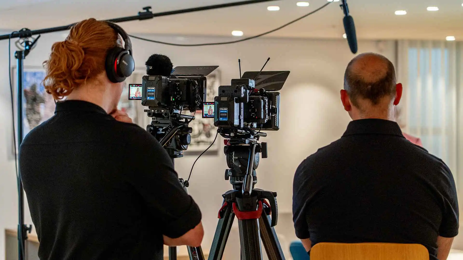 Twee crewleden van Mondha Media staan achter hun camera's tijdens de opnames van een interview voor de Werken bij ministerie van SZW campagne.